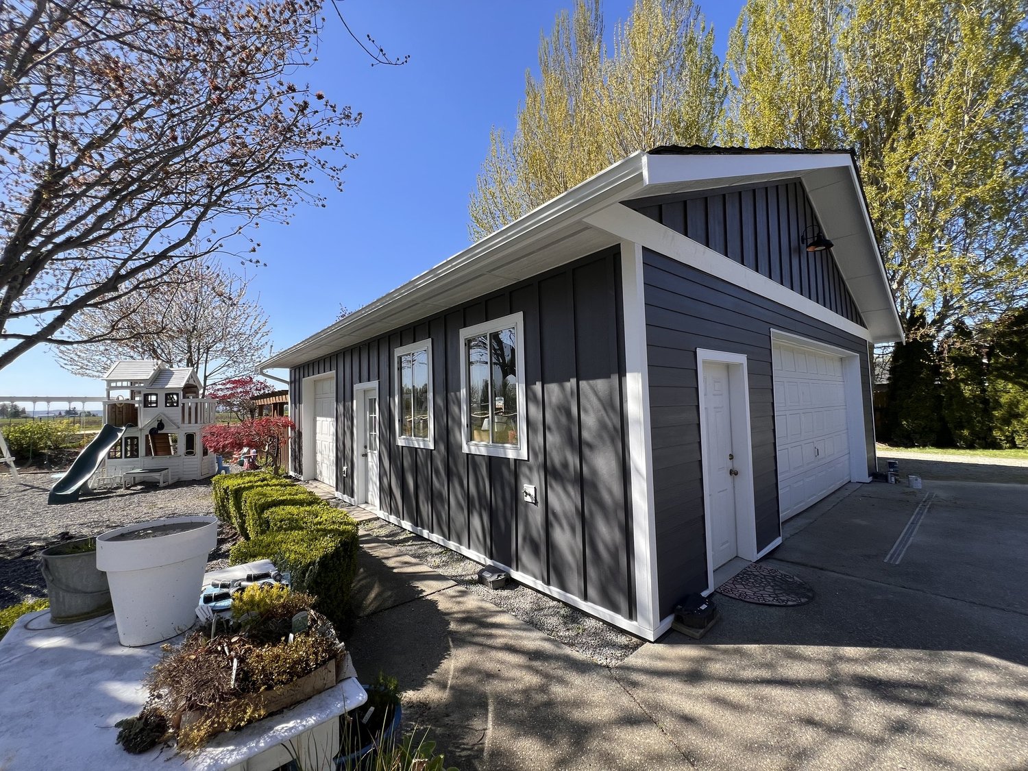 Dark gray detached garage with fresh exterior paint